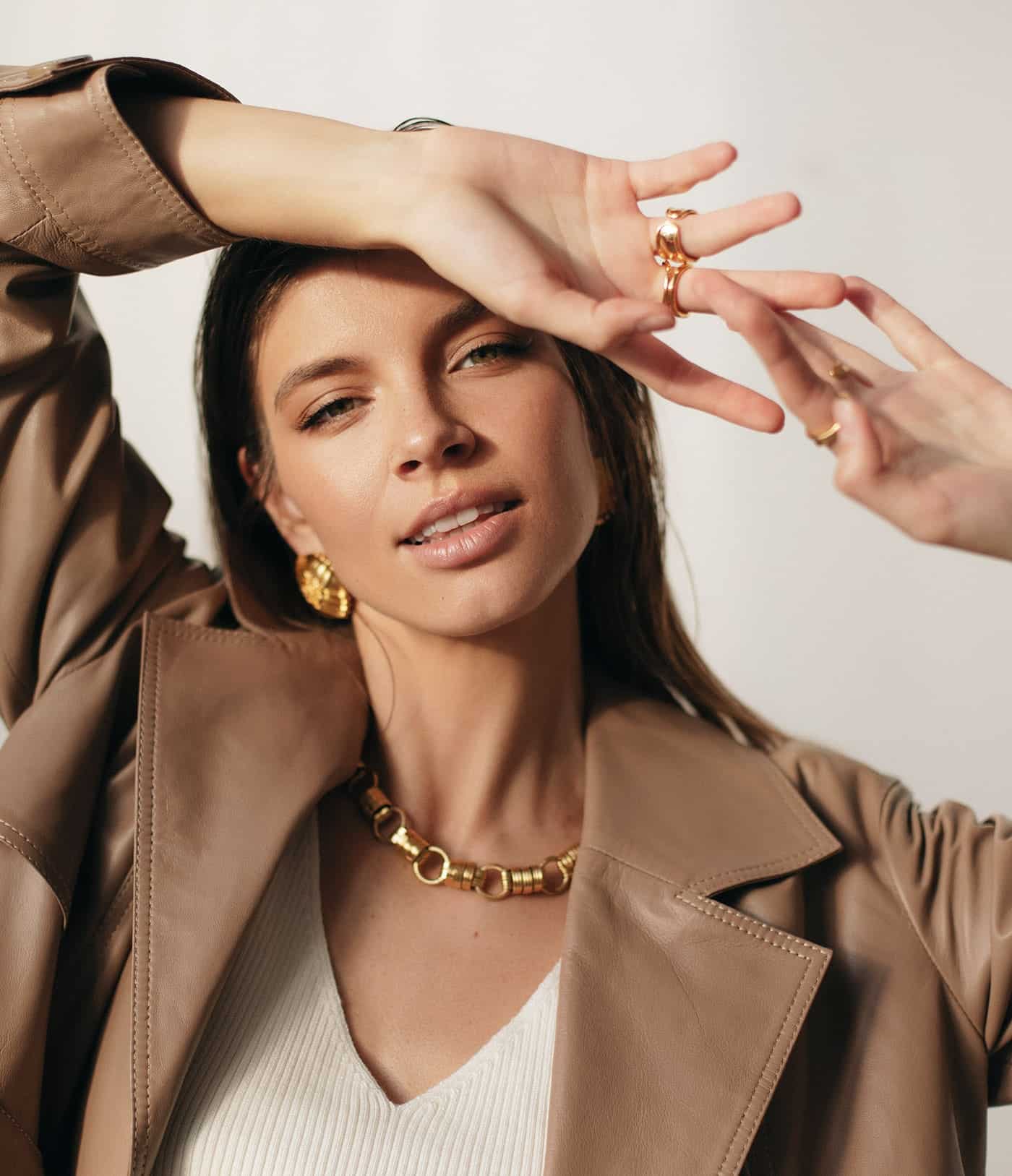 Woman wearing gold jewelry in warm editorial light